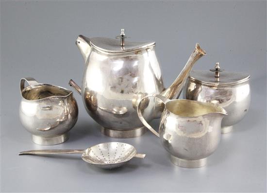 A stylish 1970s silver four piece tea set with tea strainer by Graham Watling of Lacock, gross 51 oz.